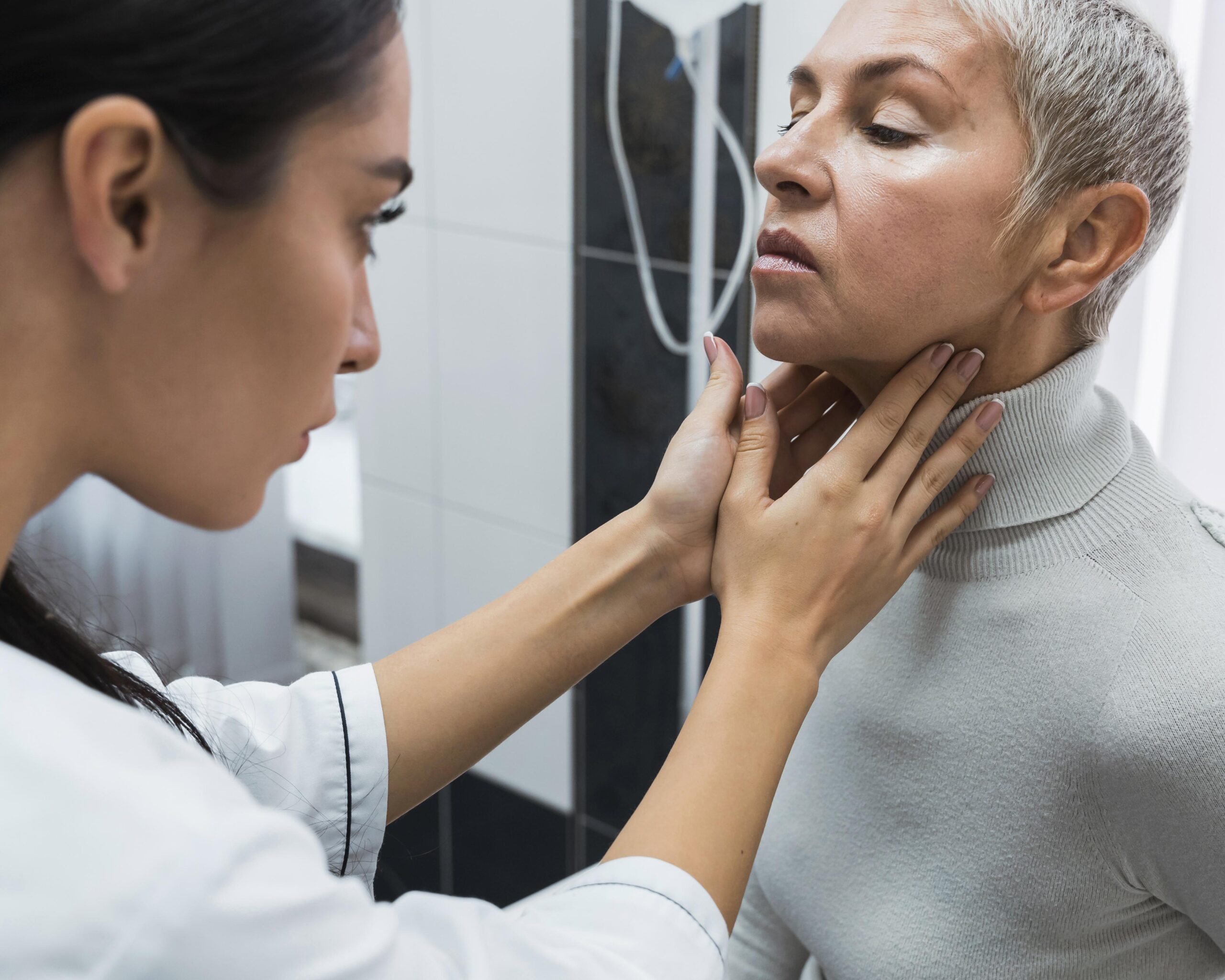 Médico examinando por palpação a região cervical de um paciente durante consulta